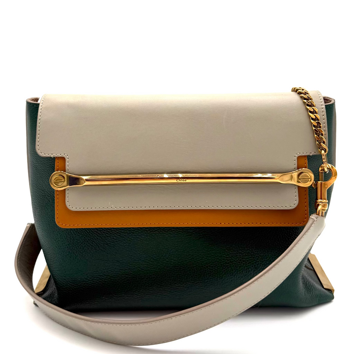 A color-blocked leather shoulder bag with a dark green base, a cream flap, a tan leather band, and gold-tone hardware, including a gold chain strap.