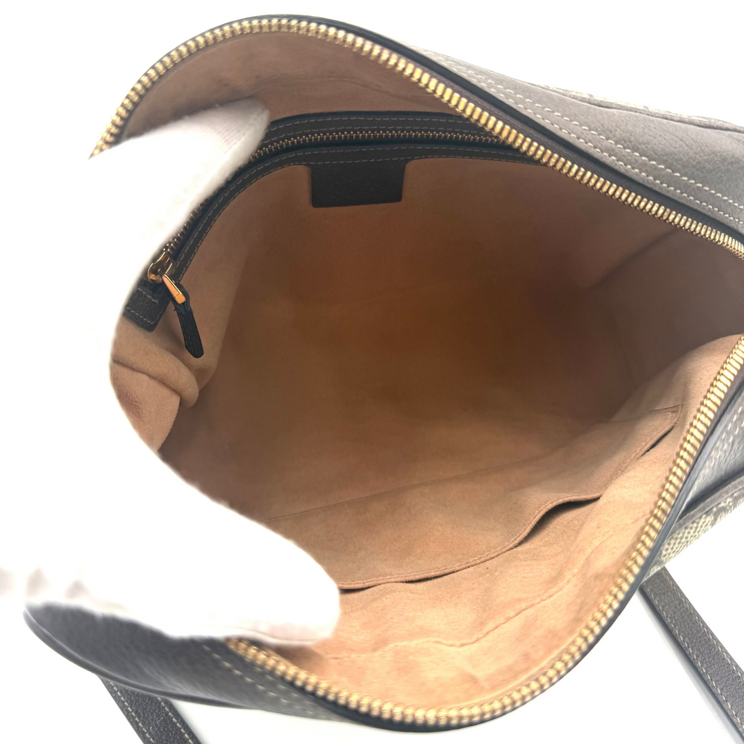 Open view of a dark gray leather shoulder bag showing the tan suede-like interior lining and gold-tone zipper.