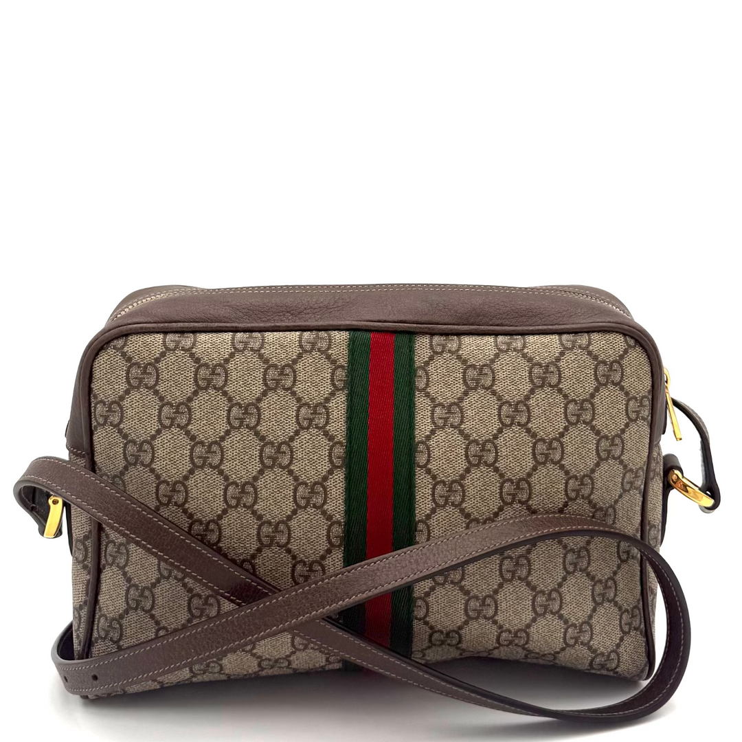 A Gucci GG Supreme crossbody bag in beige and brown with the signature green and red web stripe, shown on a white background.