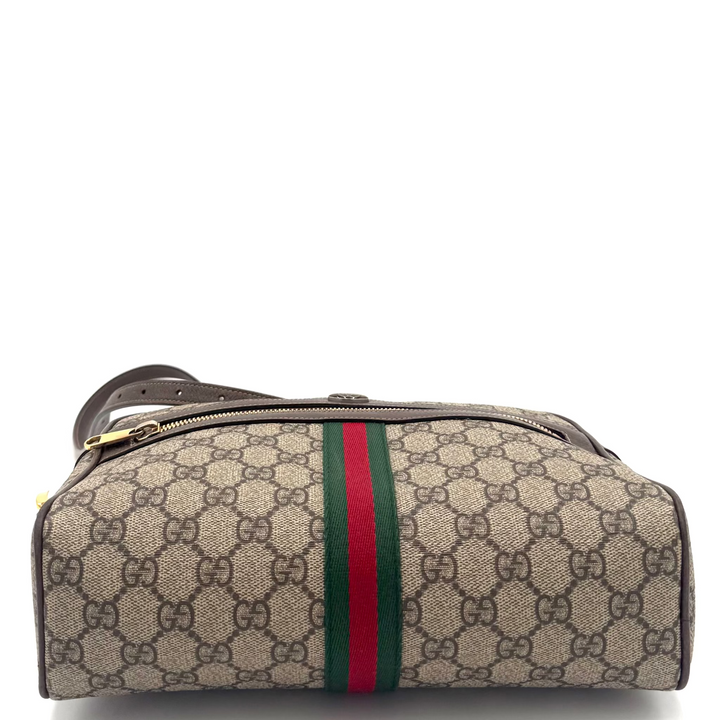 A Gucci monogram canvas toiletry bag with a green and red web stripe down the center, shown on a white background.