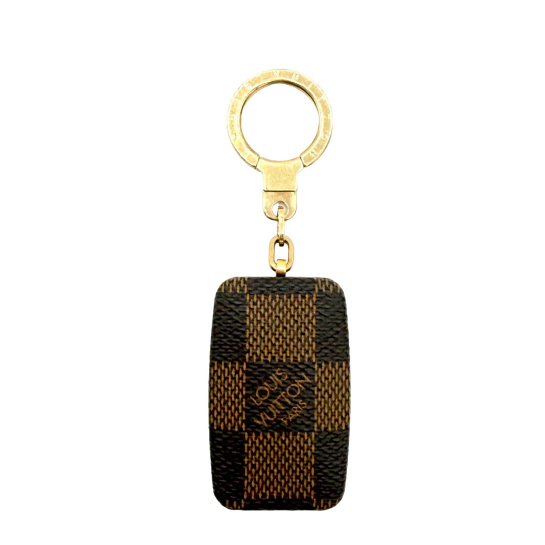 Louis Vuitton Damier Ebene checkered canvas keychain with a gold-tone metal key ring and clasp, on a white background.